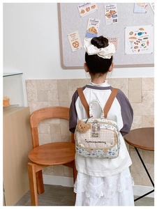 Detail of floral kids backpack with cute bear pendant and brown checkered front pocket