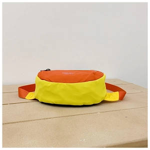 Detail view of the yellow and orange nylon kids chest bag with adjustable strap