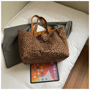Gros plan détaillé d'un sac cabas en toile léopard avec poche avant et doubles poignées
