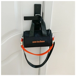 Detail of black mini cylinder bucket bag with orange lettering and woven rope accent