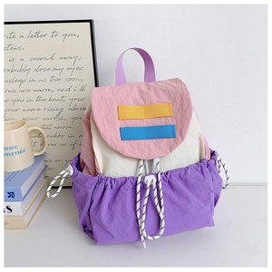 Detail of color-block kids backpack showing drawstring closure and nylon fabric texture