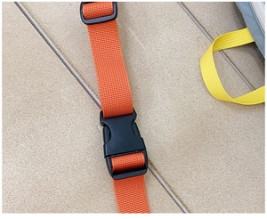 Detail of adjustable orange strap and black plastic buckle on kids casual crossbody bag