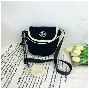 Détail du sac bandoulière noir en toile avec broderie Free Life et mini pochette ronde