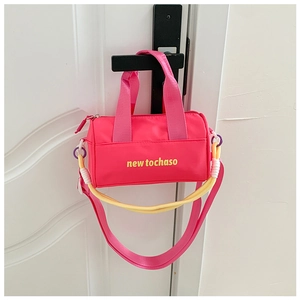 Close-up of rose red nylon bucket bag with yellow lettering hanging on a door handle