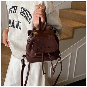 Detail of cute cat-shaped mini backpack with matte finish and 3D ears shown by model