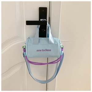 Detail of light blue bucket bag showing purple text and decorative climbing ropes