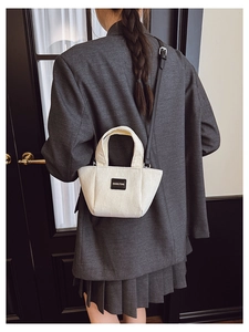 Détail d'un mini sac seau en velours côtelé blanc avec bandoulière cuir noir sur modèle