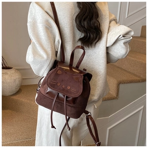 Detail of dark brown mini cat backpack with cute 3D ears and embroidery on a child back