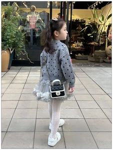 Close-up of a quilted black and white mini crossbody chain bag for children