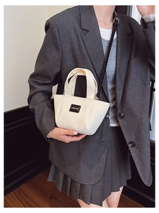 Détail du sac seau en velours côtelé blanc cassé avec patch en cuir et bandoulière