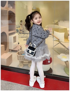 Close-up of small black and white quilted chain strap crossbody bag for children
