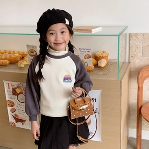 Toddler girl in color-block sweatshirt and brown polka dot mini crossbody bag