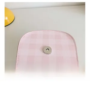 Detail of pink plaid kids crossbody bag showing metal magnetic buckle and stitching