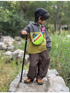 Detailed view of kids crossbody chest bag featuring vibrant neon green and blue contrast colors