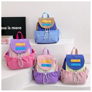 Close-up of lightweight nylon mini drawstring backpacks in various vibrant color block designs