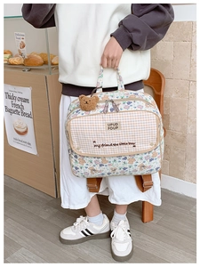 Close-up of floral bear pattern and embroidered front pocket on a kids backpack
