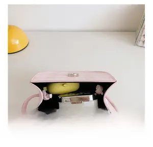 Detail view of pink plaid mini bag interior showing capacity for cosmetics and accessories
