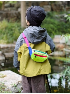 Outdoor shot of kid wearing a colorful patchwork nylon chest bag with adjustable strap