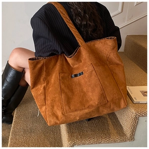 Vue macro du sac cabas en daim marron avec doublure léopard et détail de poche avant