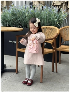 Detailed view of pink quilted mini handbag for kids featuring a decorative bow and gold rings