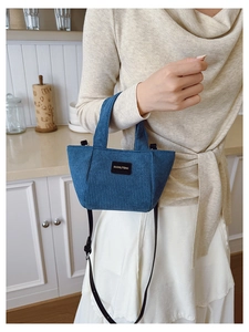Détail du sac seau enfant en velours côtelé bleu avec étiquette de marque en cuir