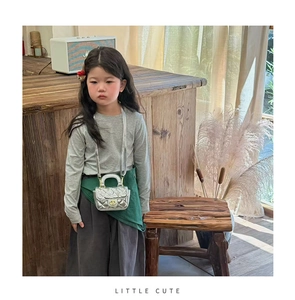 Detail of silver quilted cross-body bag for girls with golden twist lock and chain strap