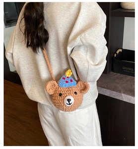 Détail macro d'un sac à bandoulière ours au crochet marron avec chapeau de fête