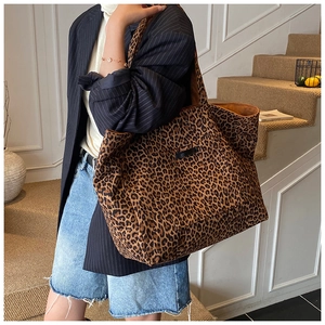 Détail du grand sac cabas imprimé léopard avec écusson noir et bandoulière assortie