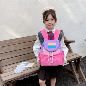Colorful multi-pocket kids backpack for school with drawstring sides worn by a girl