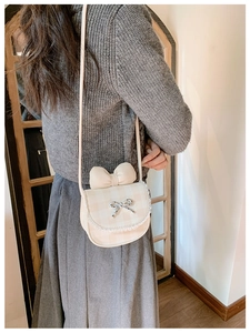 Close-up of beige plaid crossbody bag with leather bow and delicate lace trim detail