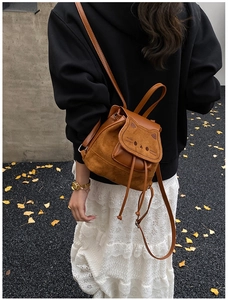 Detailed view of brown cat-themed suede backpack with drawstring and embroidery