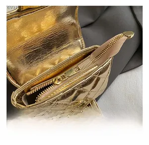 Detail of golden quilted mini bag featuring premium metal zipper and turn-lock closure