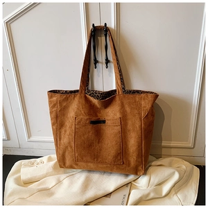 Détail d'un sac cabas en daim avec doublure léopard suspendu à une poignée