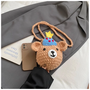 Détail d'un sac à bandoulière en crochet pour enfant avec un ours brun et chapeau