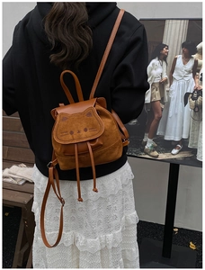 Street view of a brown cat-shaped backpack featuring cute ears and embroidery detail
