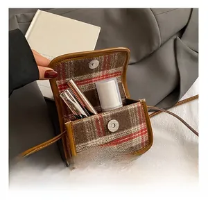 Macro detail of plaid kid bag interior showing capacity for small essentials