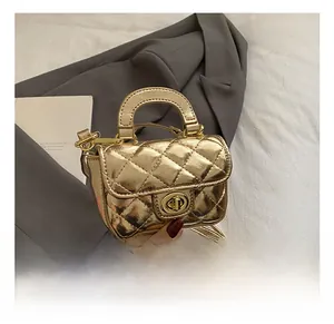 Detail shot of mini gold quilted bag with metal turn-lock and chain strap for girls
