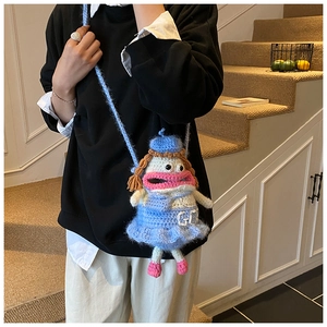 Détails d'un sac à bandoulière en crochet bleu rigolo avec visage et motif GG brodé
