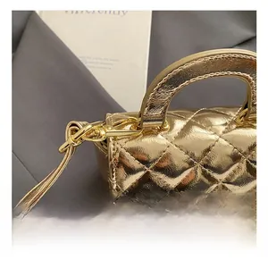 Detailed view of the gold lobster clasp and quilted texture on a mini chain handbag