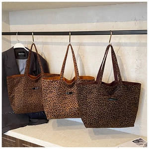 Détail de sacs cabas à motif léopard en trois couleurs suspendus sur un support