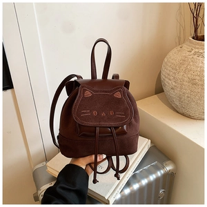 Detail of a brown cat-themed backpack featuring embroidery and smooth leather textures