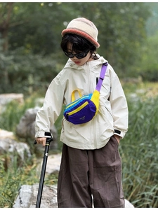 Close-up of kids multicolor nylon chest bag with adjustable strap in outdoor forest setting