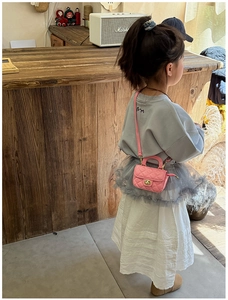Detailed view of pink quilted mini crossbody bag for girls with metal turn-lock closure