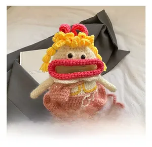 Détail du sac tricoté main avec cheveux jaunes et robe rose, design dessin animé unique