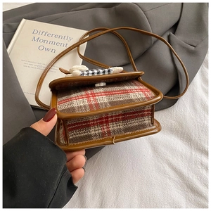 Detail of kids plaid crossbody bag with plush bunny ornament and leather trim edge