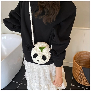 Détail du sac panda crocheté à la main avec une feuille verte et une bandoulière tricotée