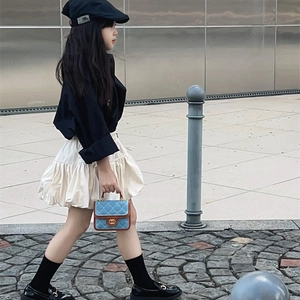 Girl's Korean fashion set with black shirt, ruffle skirt, and blue quilted chain bag