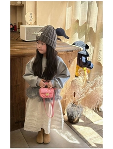 Toddler girl modeling a pink quilted chain bag with grey sweater and pleated skirt