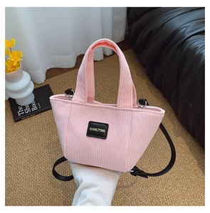 Sac seau en velours côtelé rose pour enfants sur tapis avec fleurs et livres