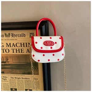 Detail of red polka dot mini bag with golden chain and bear logo for girls
